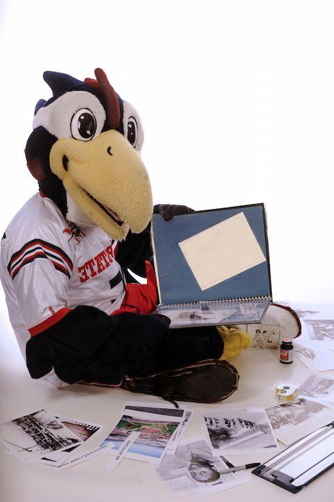 Rowdy Roadrunner mascot looking through old photos